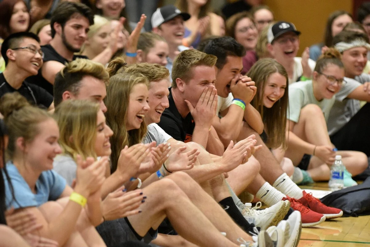 High school students laughing during a comedy hypnosis show