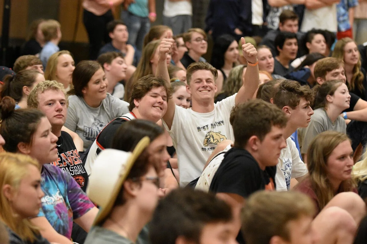 Student giving double thumbs up at a high school event